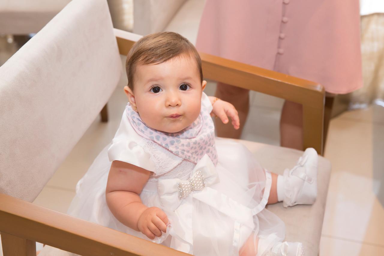 Bebê com vestido branco em registro de batizado da Fotobella